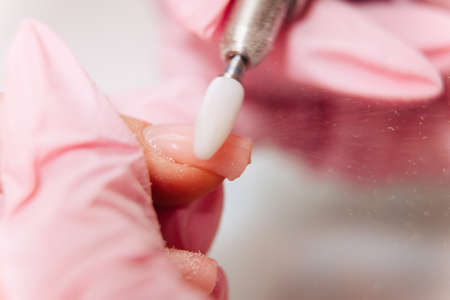 Manicure process. The master polishes the nail using an automated machine. Drill polish remover.の写真素材