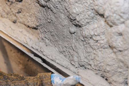 The final stage of plastering the walls. A worker levels the plaster with a leveler.の写真素材
