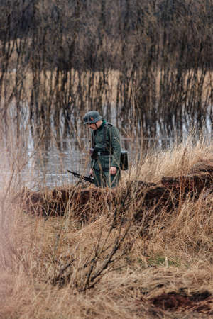 VIKHOREVKA, RUSSIA - May 09, 2021: Reconstruction of the 1941-1945 hostilities between the armies of Germany and the USSR. The German machine gunner is hiding in the grass.のeditorial素材