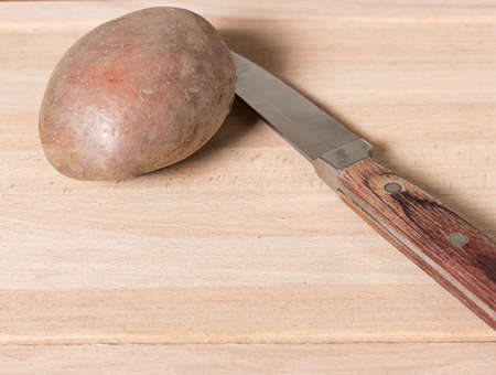 Raw red potato and the knifeの写真素材