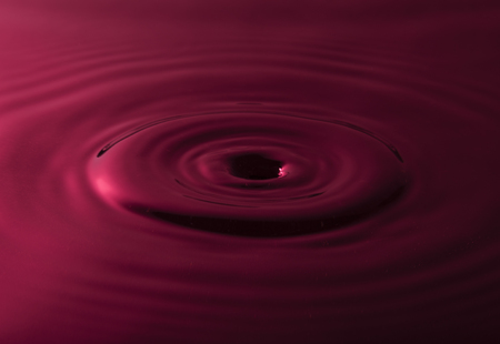 Water drop falling into water making a black holeの写真素材