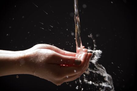 Water is poured into the palms of your hands and sprayの写真素材