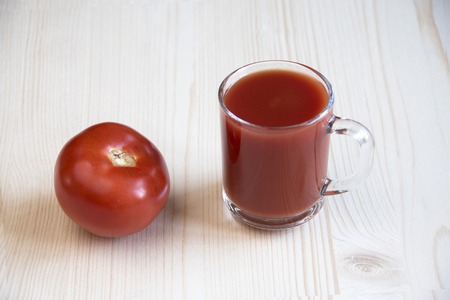 Cup of tomato juice and whole tomatoの写真素材