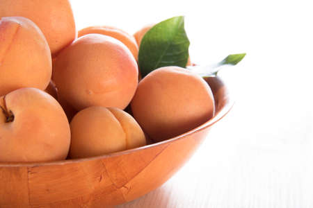 Ripe apricots in a bowl in bright lightの写真素材