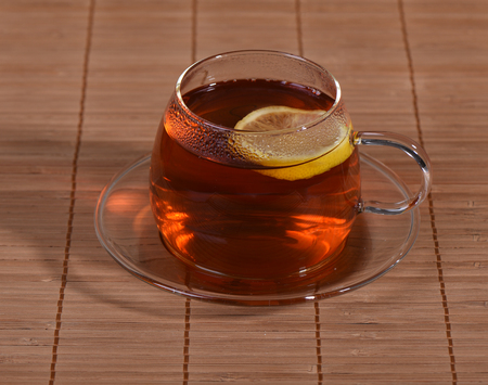 Cup of tea with lemon on a matの写真素材