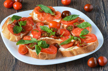 Sandwich with butter, tomatoes and basil. Close upの写真素材