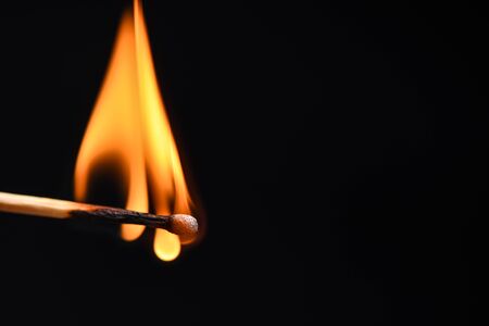 The fire spreads over a wooden match close upの写真素材