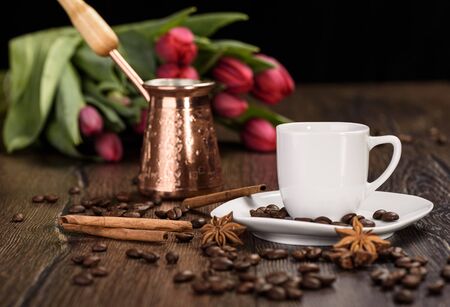 Cup for coffee, cezve against the background of tulips close upの写真素材
