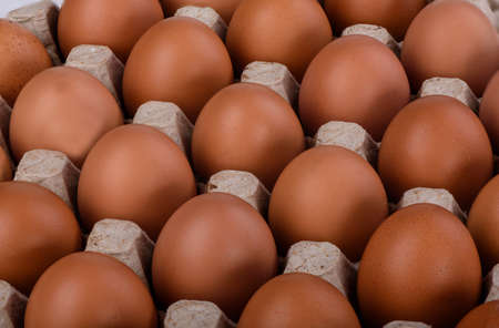 Diagonals of brown chicken eggs in a cardboard box
