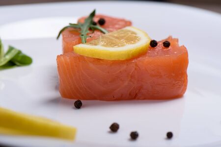 Macro shot of a slice of salmon on a white plateの写真素材