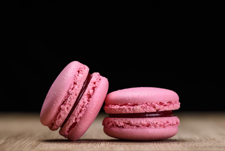 Two pink macaroons on wooden background, close upの写真素材