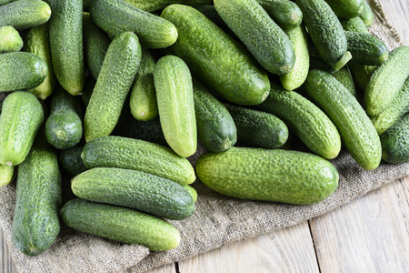 Fresh cucumber, burlap and wooden backgroundの写真素材