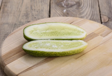Salt falls on the halves of fresh cucumberの写真素材
