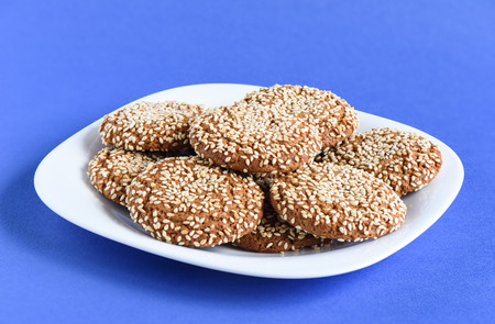 Oatmeal cookies with sesame seeds in a white dish on a violet baの写真素材