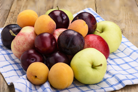 Fruit on a kitchen towel, apples, plums, apricots Rustic stileの写真素材