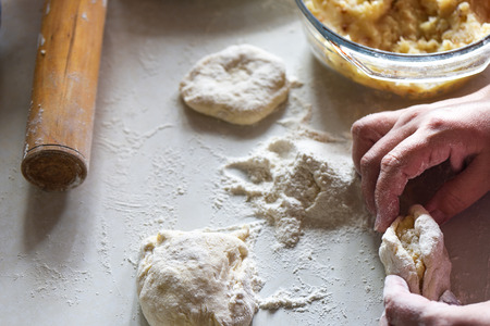 Forming a pie with potatoes by women's hands close upの写真素材