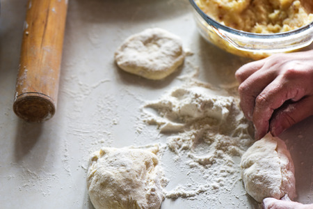 Formed raw potato pie in female hands close upの写真素材