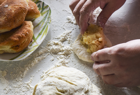 Womens hands fill a pie with stuffingの写真素材