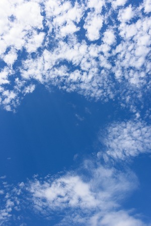 The blue sky with clouds and the suns rays as a background
