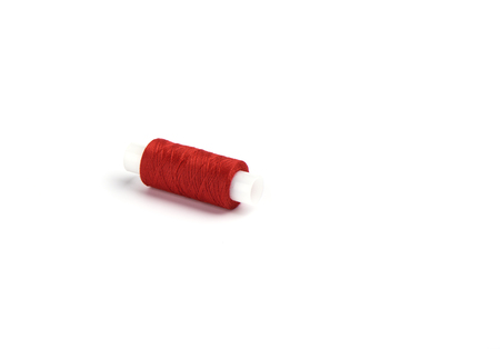 Cotton red threads on the plastic sleeve for the sewing machine. Sewing concept. Copy space