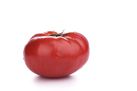 Ripe big tomato with water drops isolated on white background.. Close upの写真素材