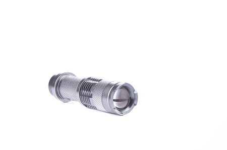 Pocket flashlight in a metal case on a white background. Copy space