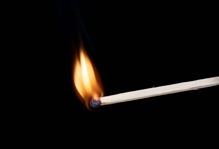 Lighting matches at the moment when it explodes. Burning match over black background. Close up. Copy space.の写真素材