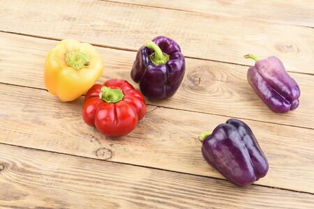Colorful fresh bell peppers on a wooden table. Rustic style.
