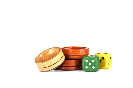 Colorful dice and wooden backgammon checkers isolated on a white background. Copy space.