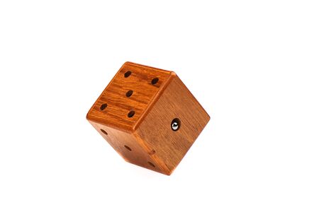 Puzzle magic cube three-dimensional maze. Wooden cube with a metal ball on a white background. Puzzle concept. Copy space.の写真素材