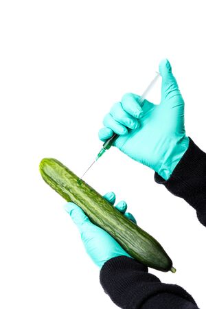 Human being injected chemicals into ripe cucumber, pesticides and fertilizers and chemicals with a syringe.の写真素材