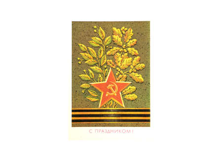 Moscow, Russia, June 07, 2020. Postcard of Soviet times with the image of a red star with a hammer and sickle, a St. George ribbon and oak leaves. Artist L. Pokhitonova. USSR postcard concept. The inscription in Russian with a holiday!のeditorial素材