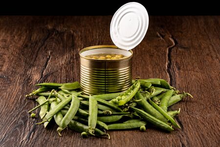 Ripe peas in pods and an open can of canned peas. Rustic style.の写真素材