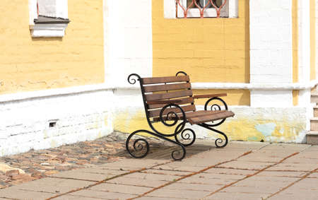 Street bench near the church wall in the courtyard.