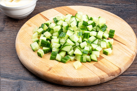 Sliced fresh cucumber on a wooden cutting board. Salad ingredients.の写真素材