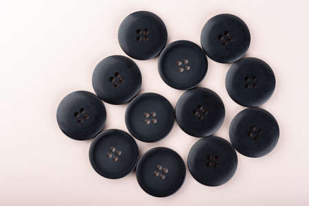 Top view of several sewing buttons on a light beige background.の写真素材