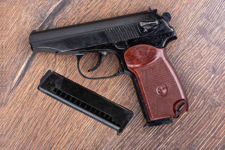 Top view of the Makarov pistol and the magazine for the cartridge on a wooden background. The main weapon of the Russian police.の写真素材