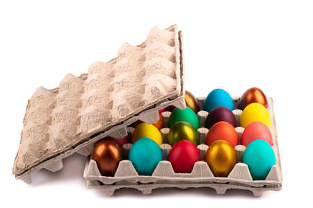 Open cardboard package with colorful Easter eggs on a white background. copyspace.