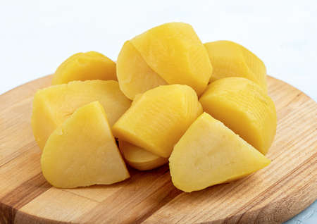 Peeled sliced boiled potatoes on a wooden cutting board. copyspace.の写真素材