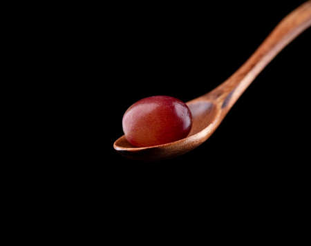 Wooden spoon with ripe grapes on a black background. copyspace.の写真素材