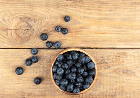 Top view of blueberries or bog whortleberry on a wooden background.の写真素材