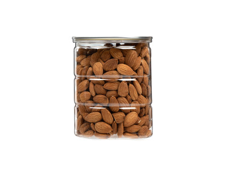 Transparent jar full of almonds on a white background. copyspace.の写真素材