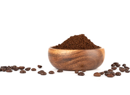 Ground coffee in a wooden bowl and coffee beans on a white background. copyspace.の写真素材