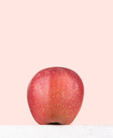 Bottom view of a red ripe apple against a pink background. copyspace.の写真素材