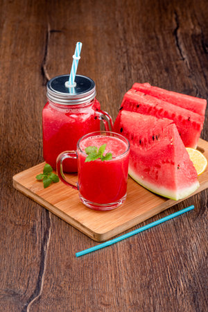 Ripe watermelon smoothie in a glass mug and jar. Healthy eating.の写真素材