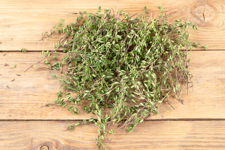 Close-up of fresh thyme sprigs on a wooden background. Copy space.