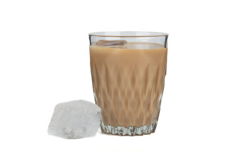 Irish cream liqueur with ice in a glass and an ice cube on a white background. Copy space.