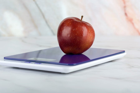 Close-up of a red apple on a kitchen scale.