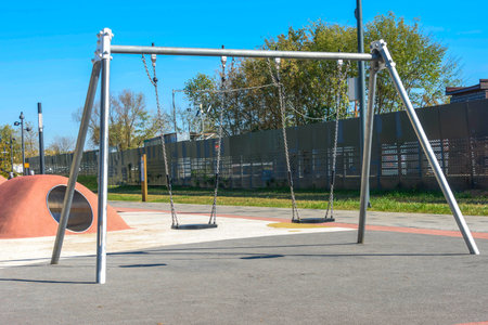 Swings on a playground in a park on a summer day.