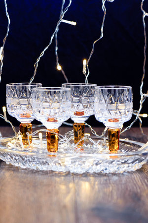 Crystal tray with crystal glasses and garland lighting. Copy space.